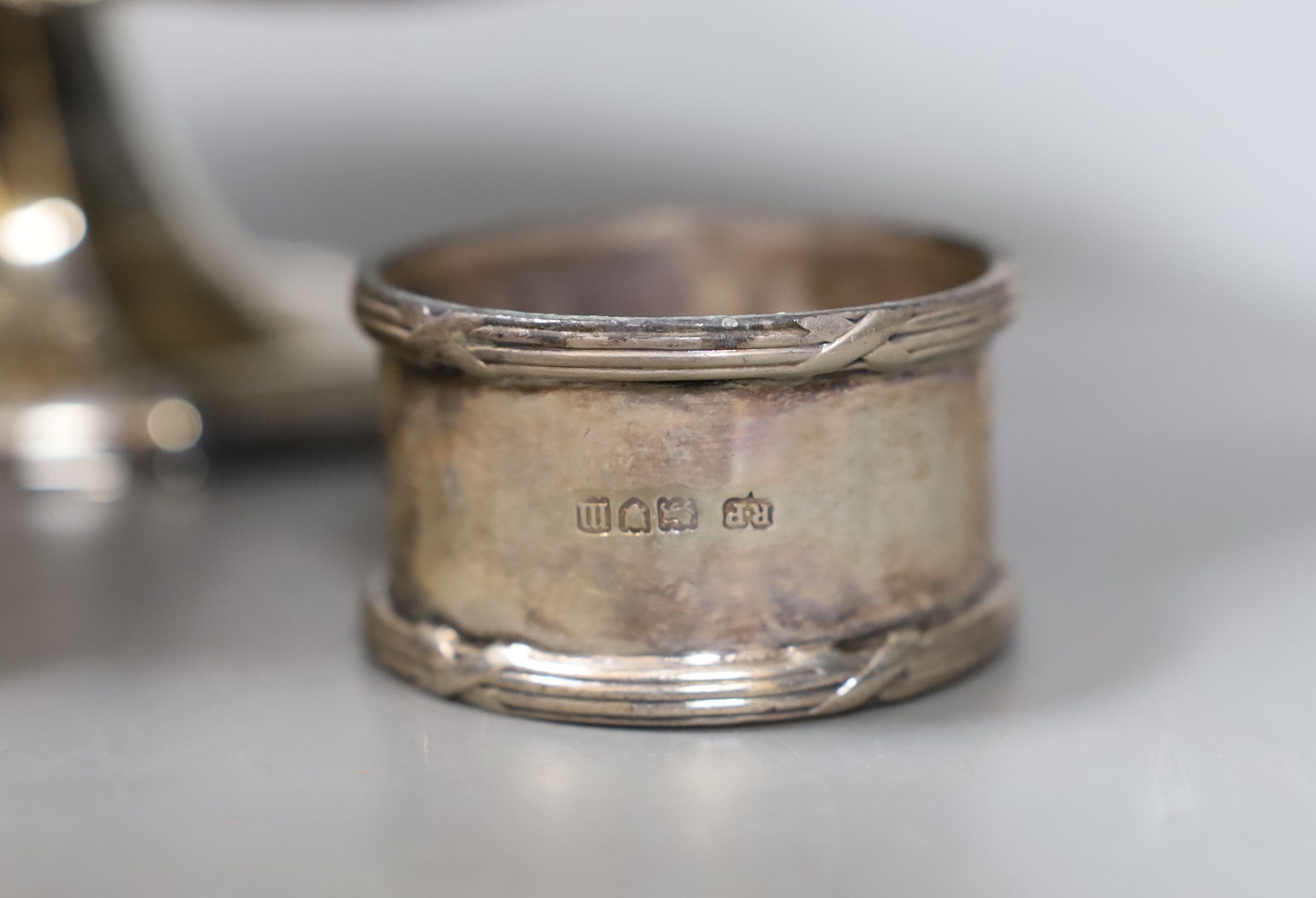 An Edwardian repousse silver pedestal bowl, Sheffield, 1901, 28.5cm and three silver napkin rings, 12.5oz.